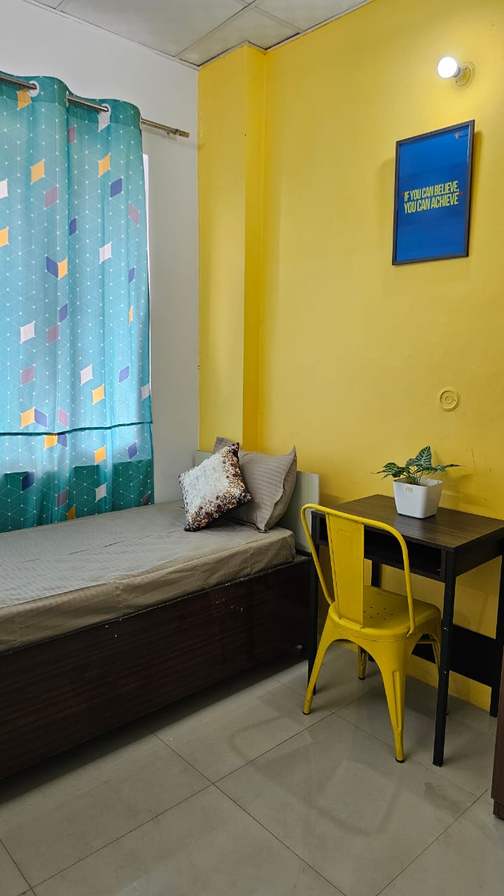 Single bed and study corner at Stag House Hostels